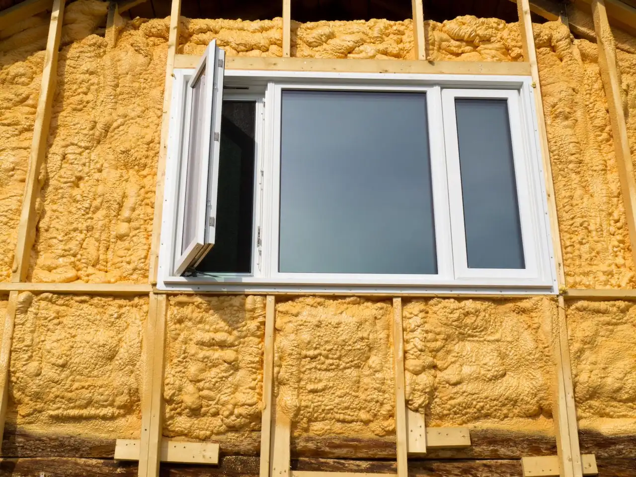 Installer applying spray foam inside a metal structure