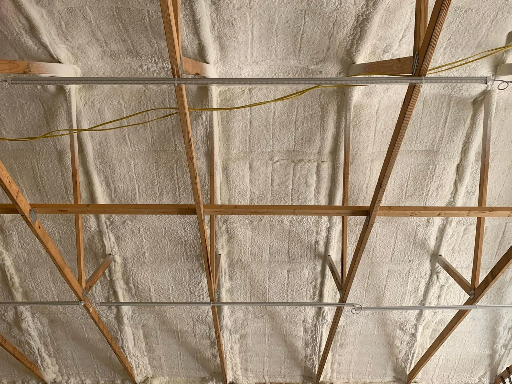 Finished spray foam coverage in a metal wall assembly